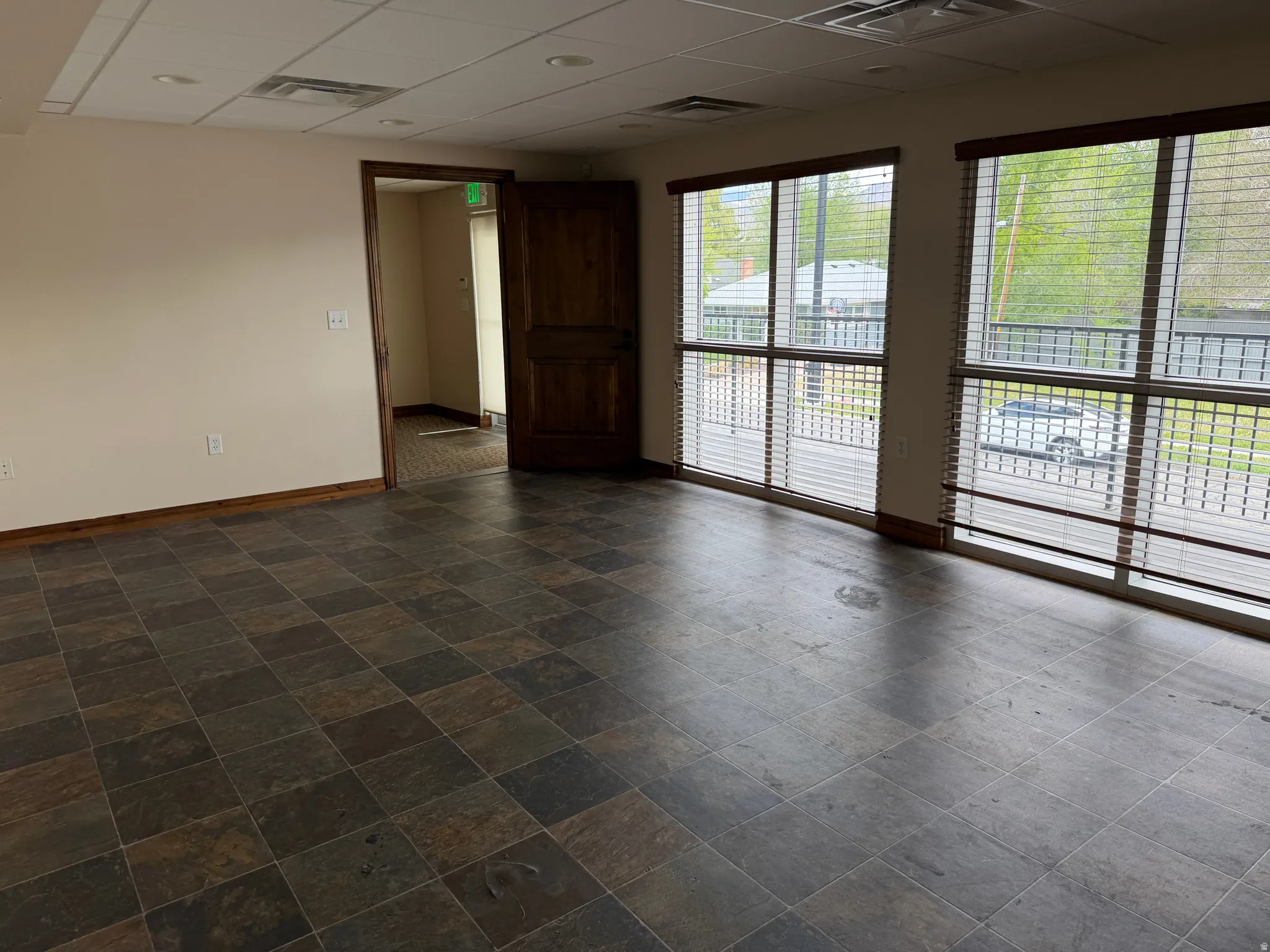 Unfurnished room featuring a drop ceiling and baseboards