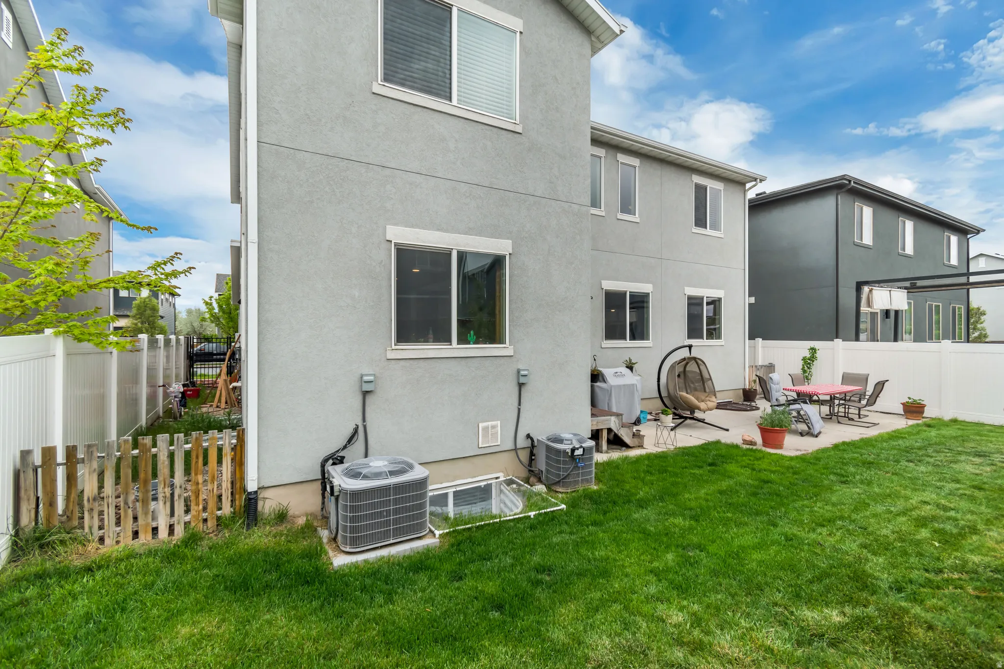 Rear view of property with a fenced backyard, stucco siding, and a patio