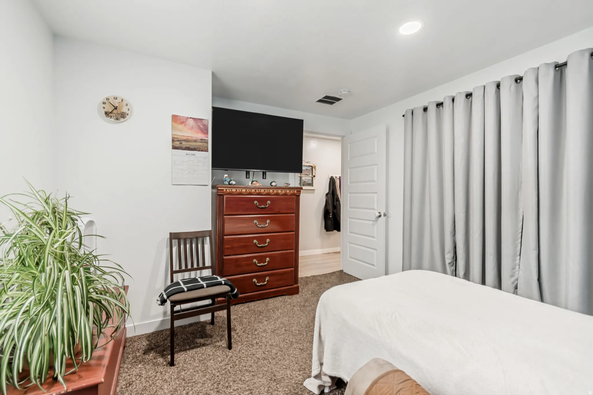Bedroom with light colored carpet and baseboards