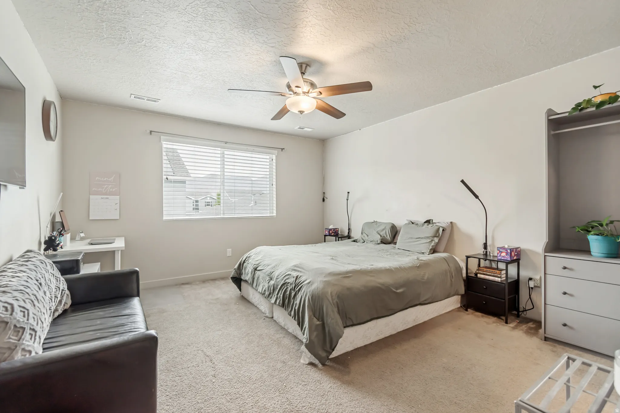 Bedroom with carpet, a textured ceiling, and ceiling fan