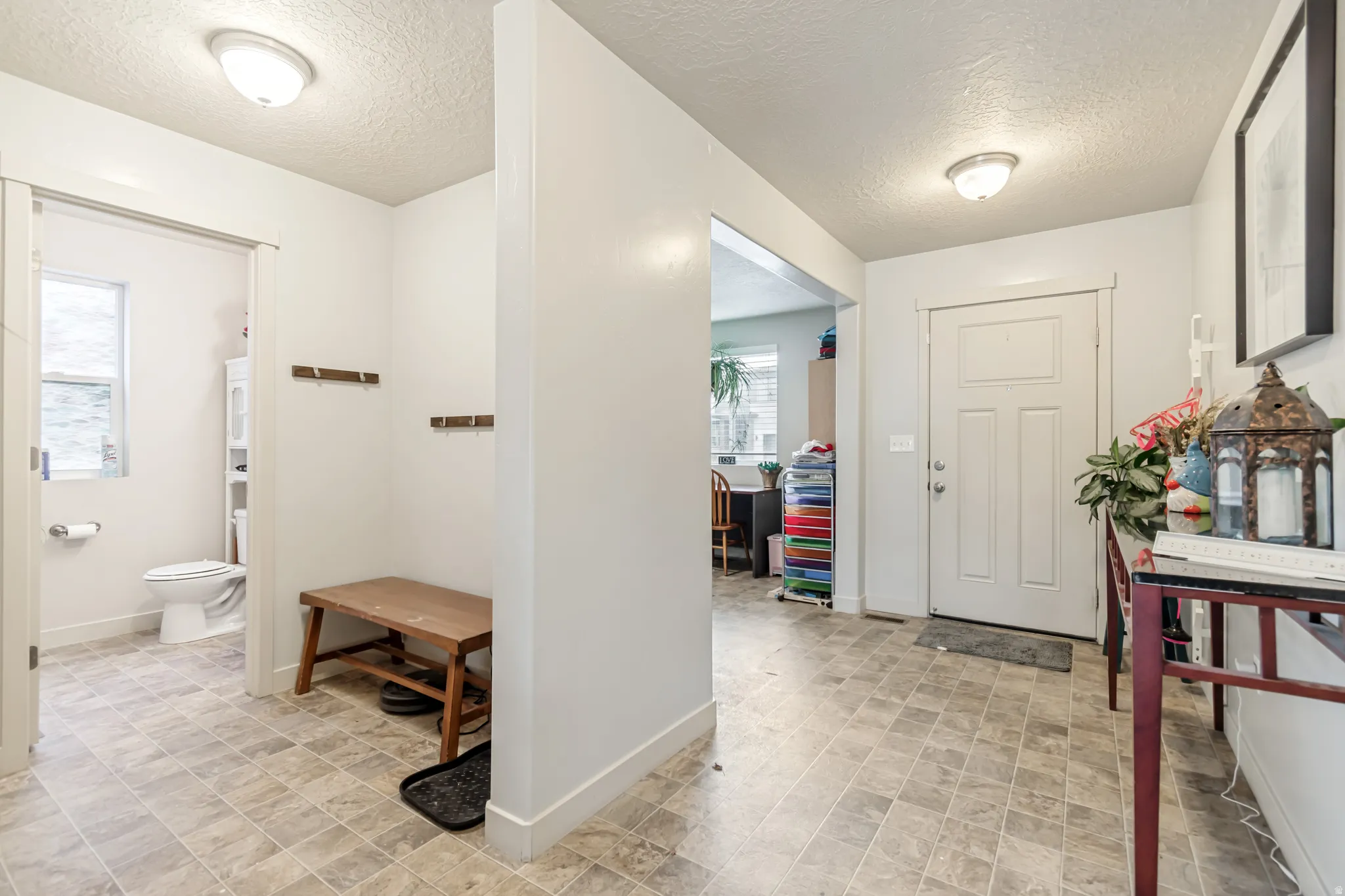 Foyer entrance featuring a textured ceiling and stone finish floors
