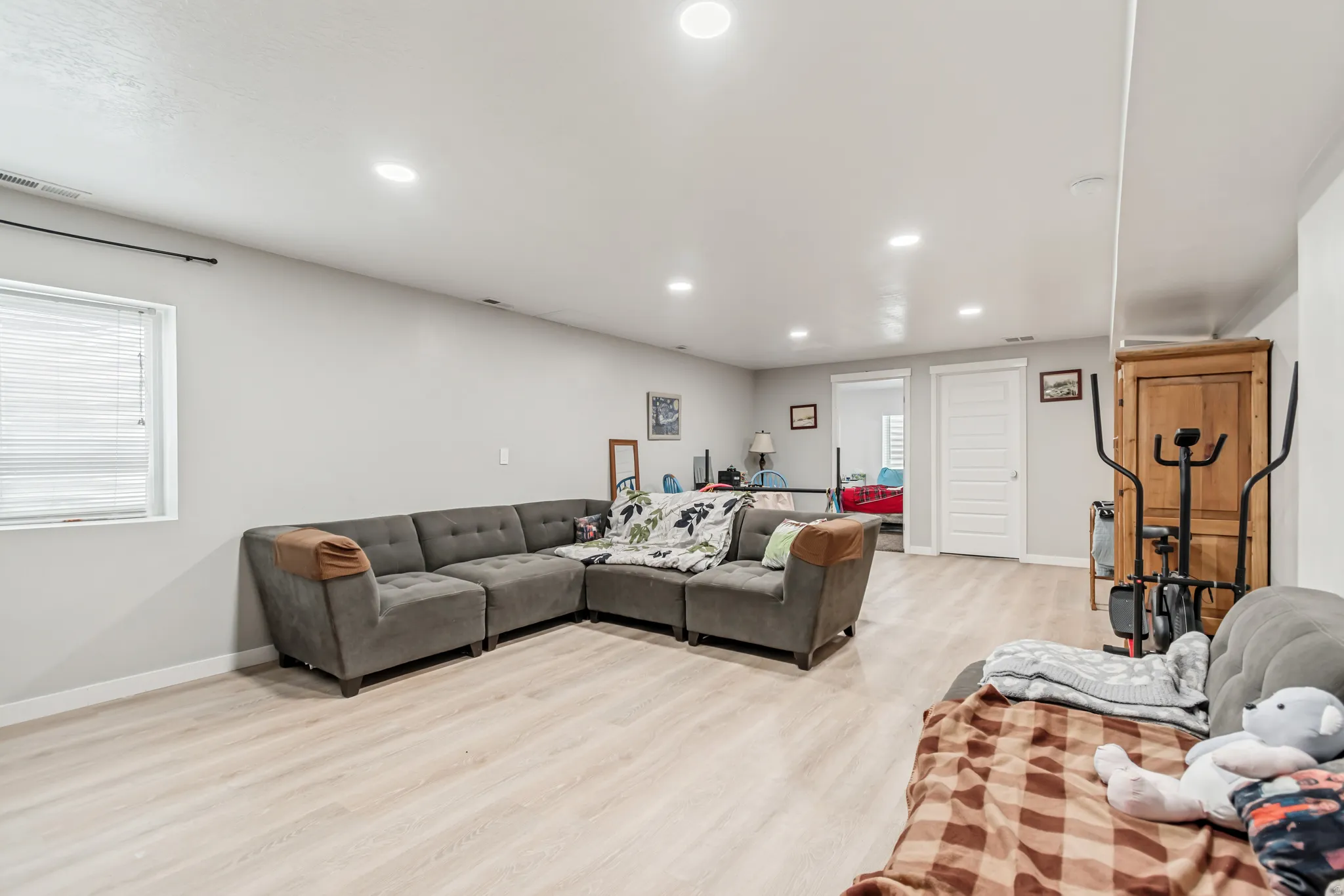 Living room with light wood-type flooring and recessed lighting