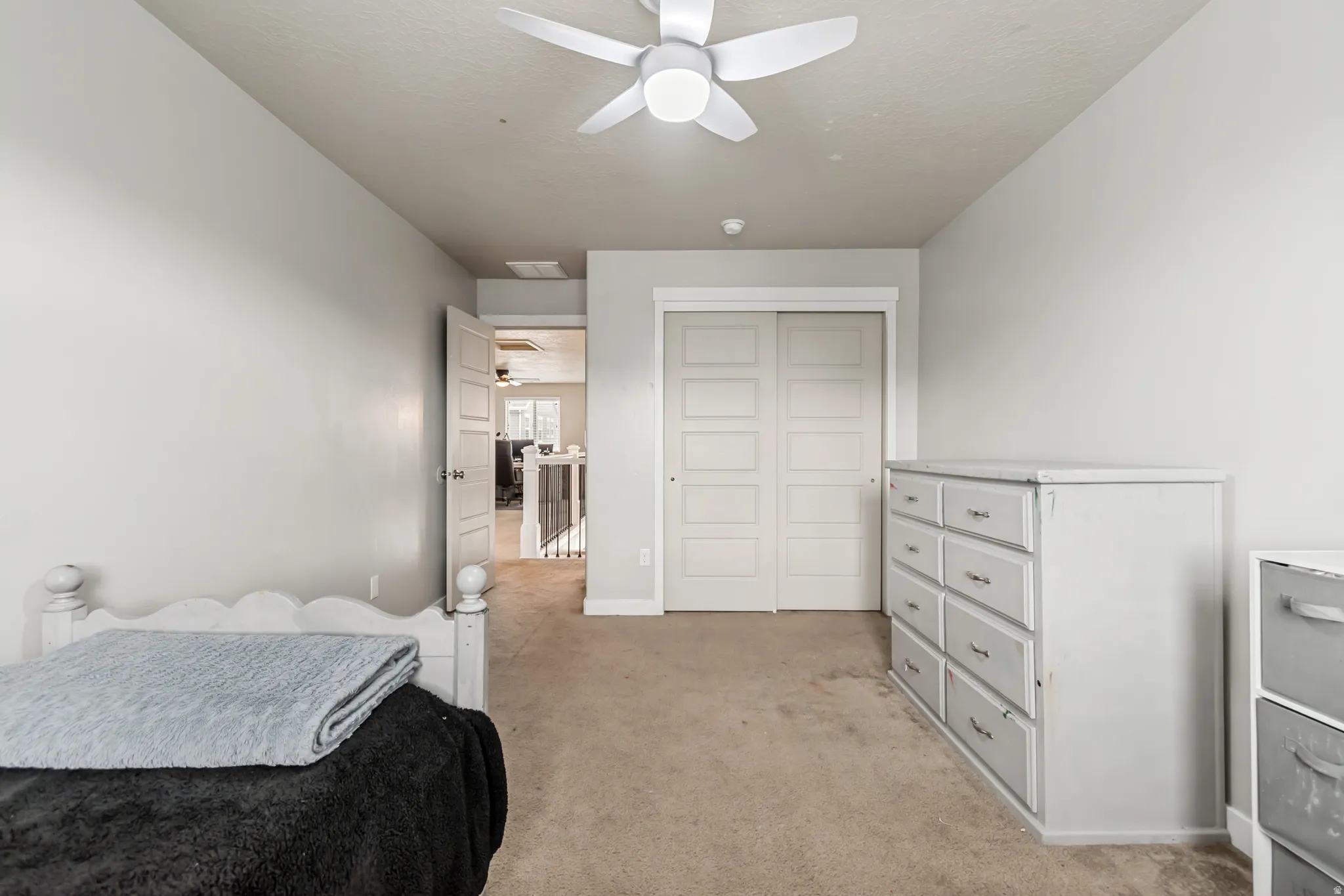Bedroom featuring light colored carpet, ceiling fan, and a closet