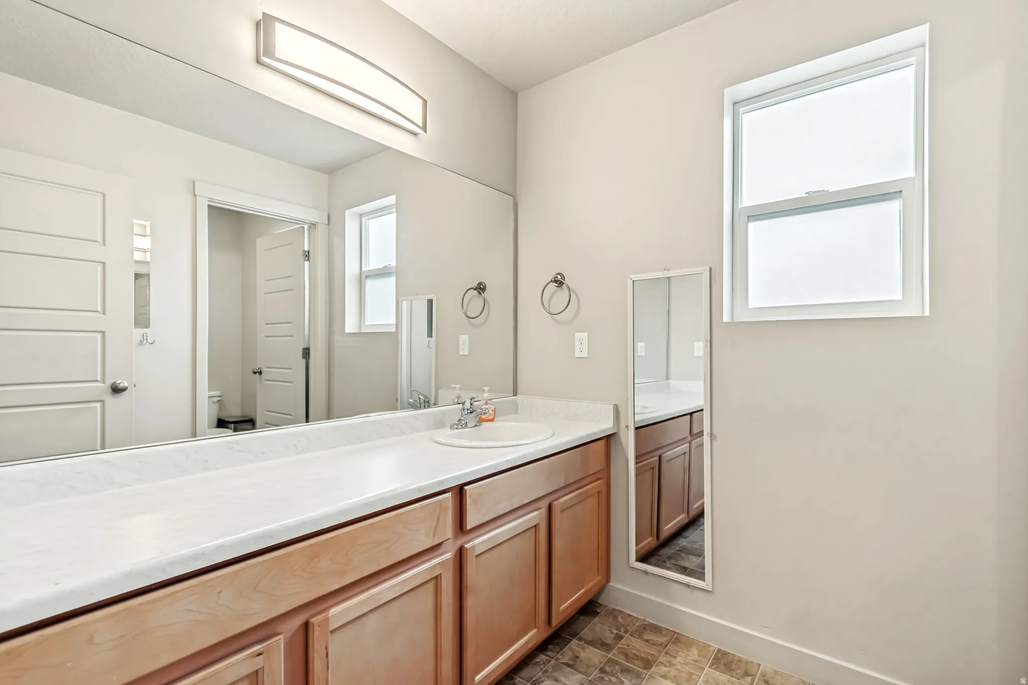 Bathroom with vanity and stone finish flooring