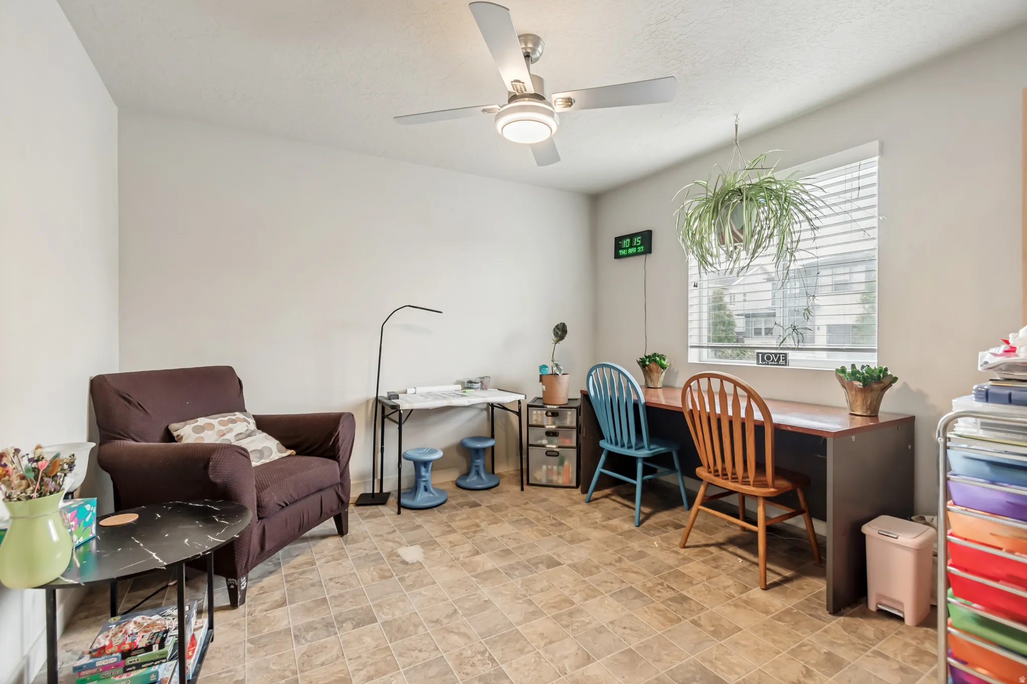 Home office featuring stone finish floors and ceiling fan