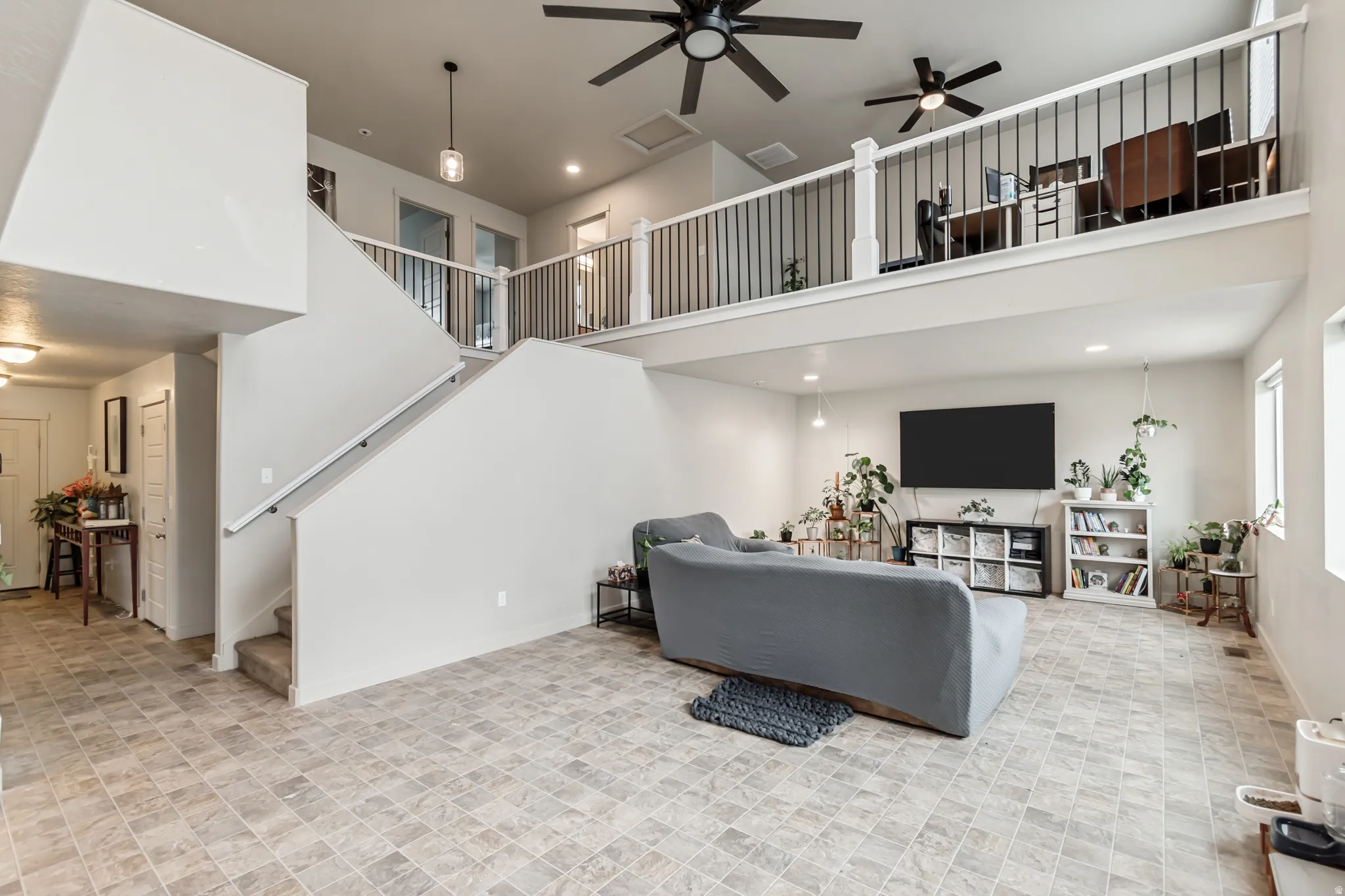 Living area featuring a ceiling fan, a high ceiling, and recessed lighting