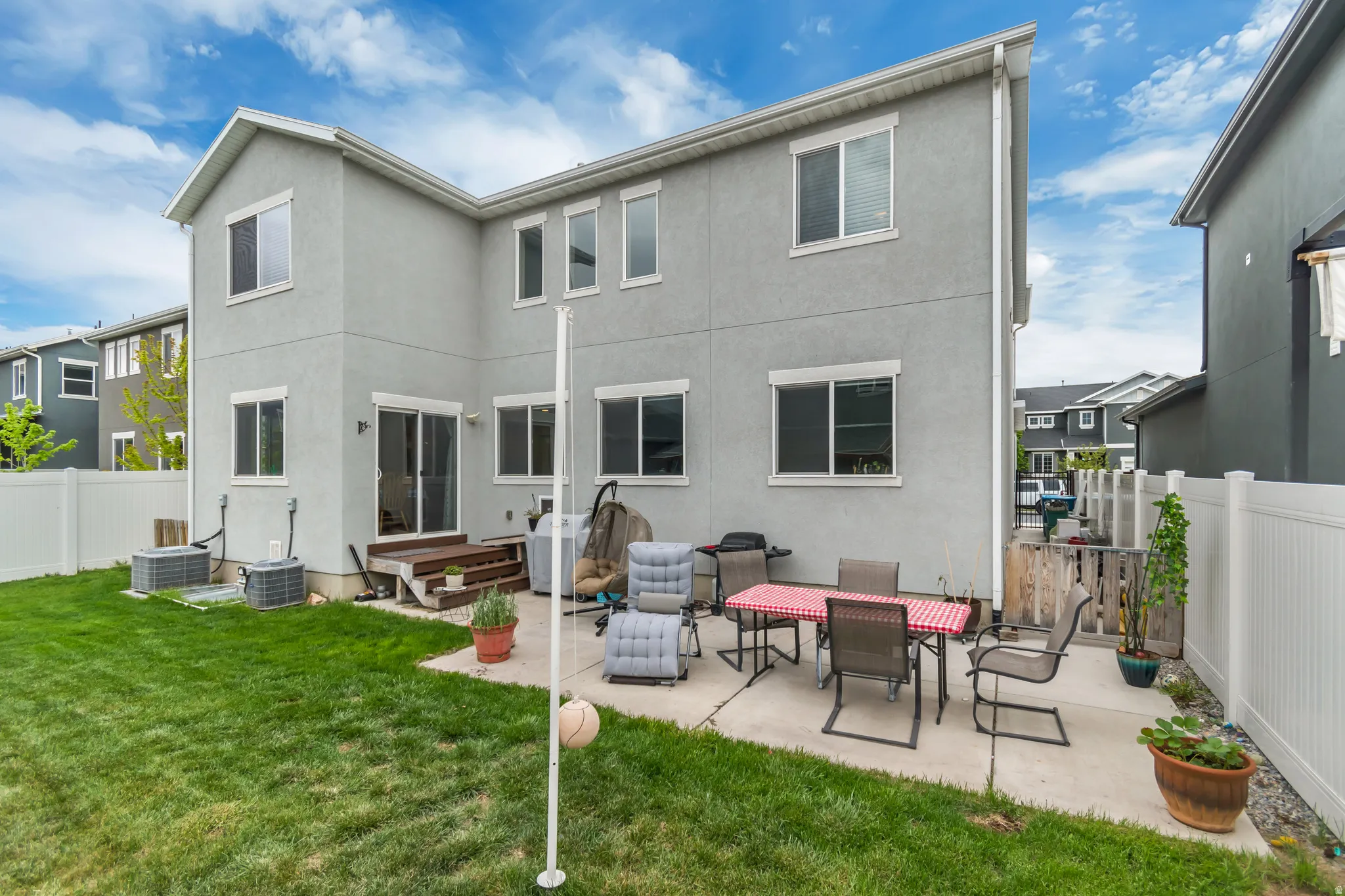 Back of property featuring a fenced backyard, a patio area, and stucco siding