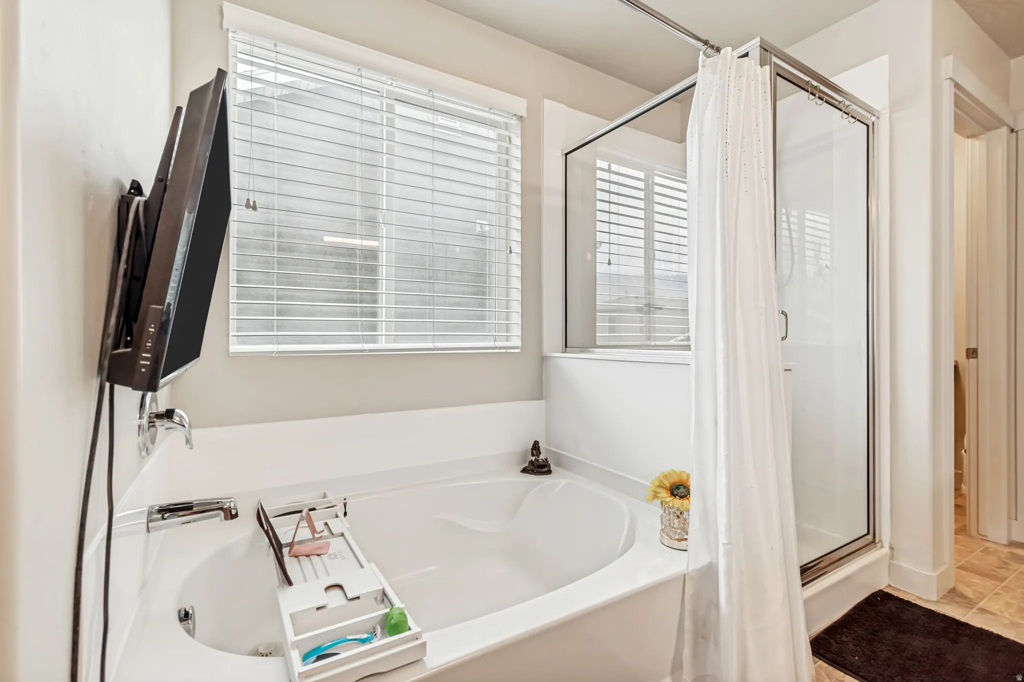 Full bathroom featuring a shower stall and a bath