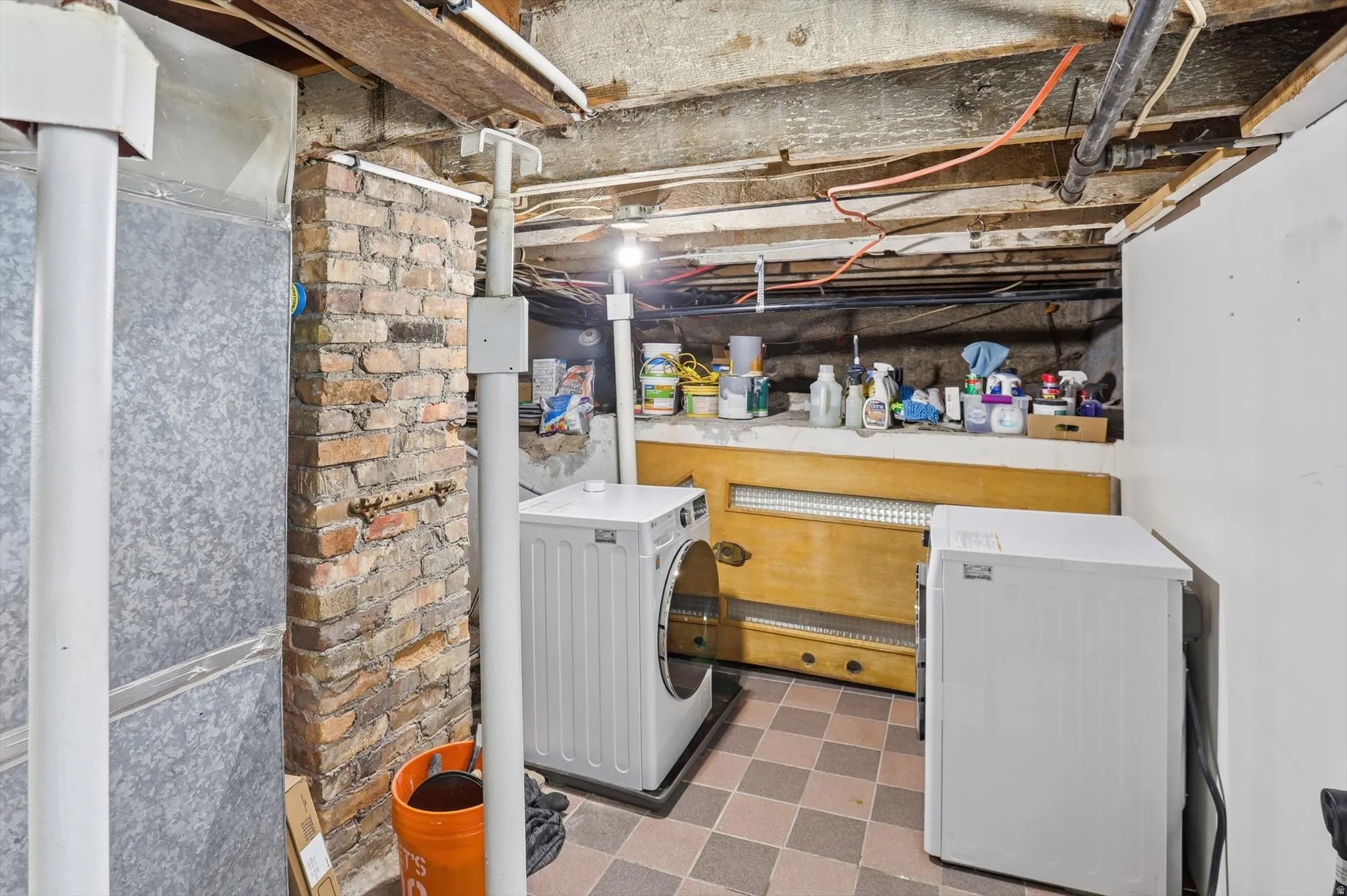 Unfinished below grade area with light flooring, heating unit, and separate washer and dryer