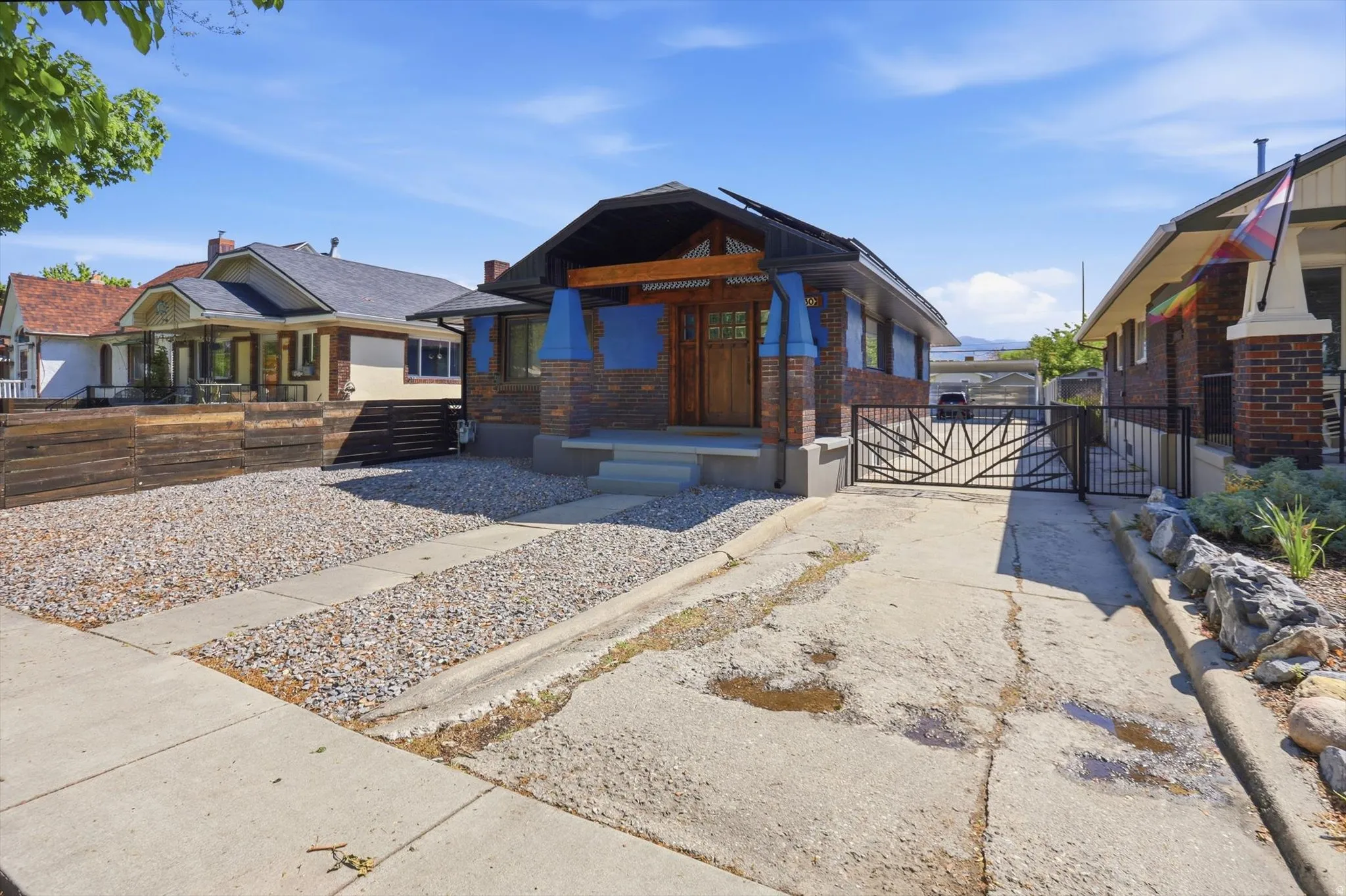 View of front of house featuring a gate and brick siding