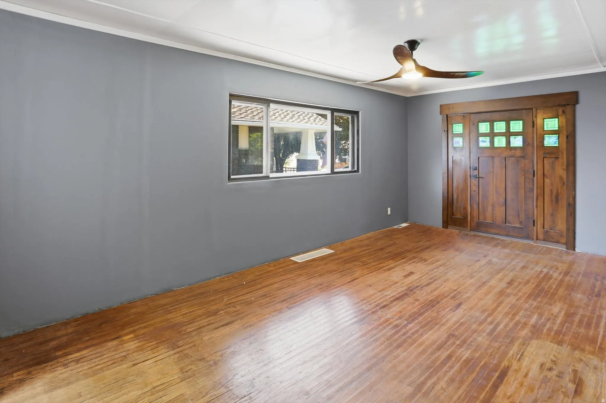 Entryway with hardwood / wood-style floors, a ceiling fan, and crown molding