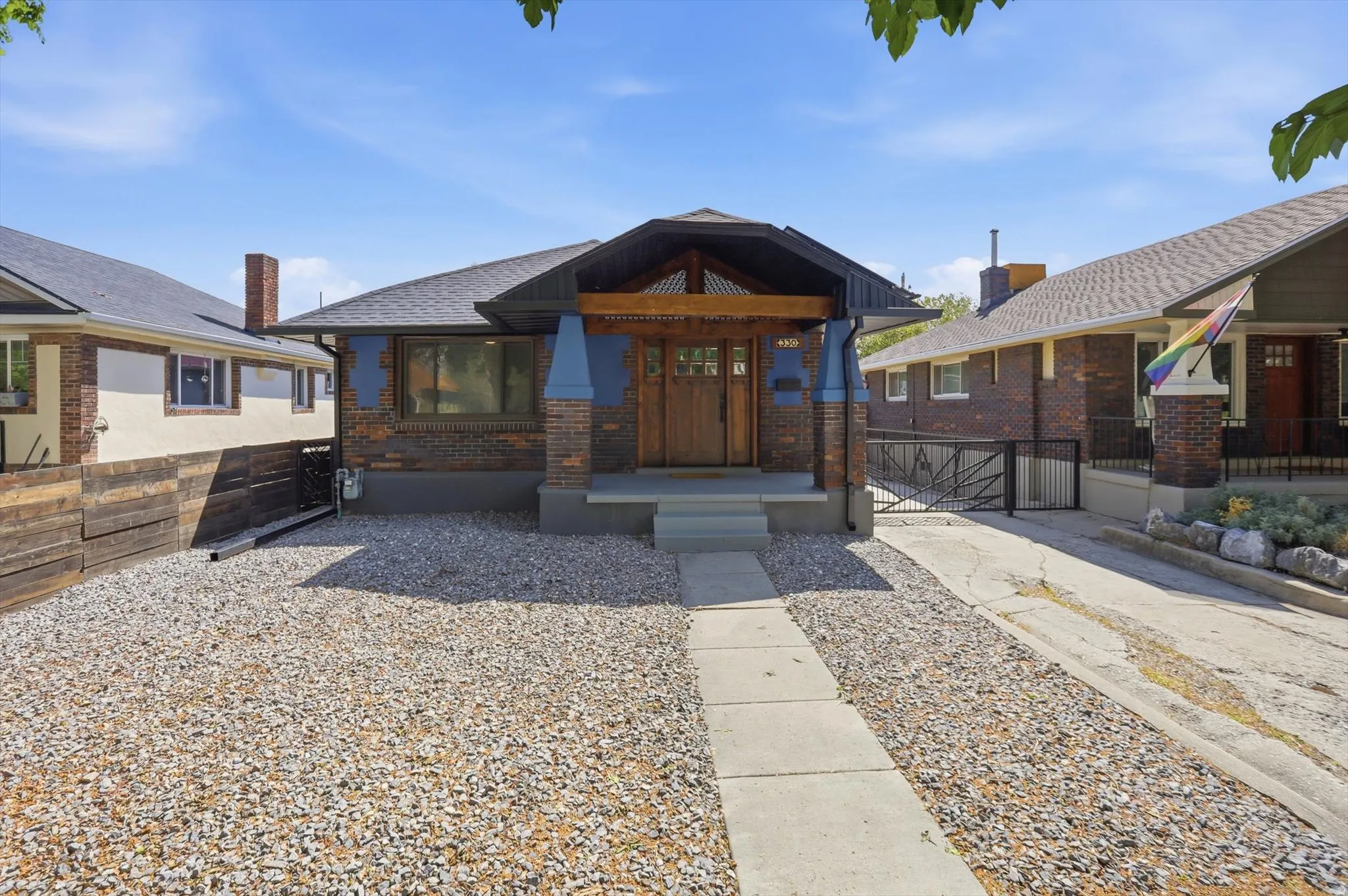 Bungalow-style house featuring brick siding, a gate, and a porch