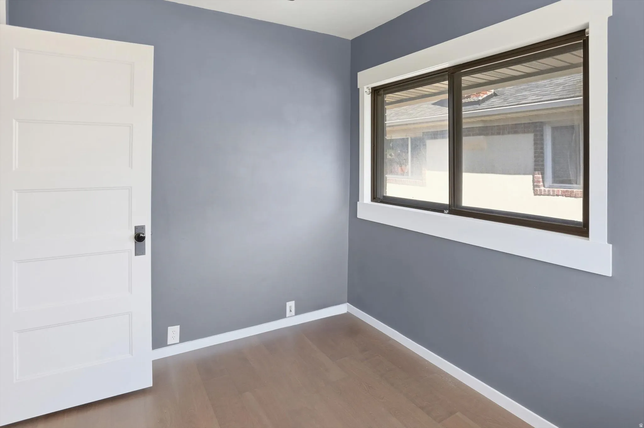 Empty room featuring baseboards and dark wood-style floors