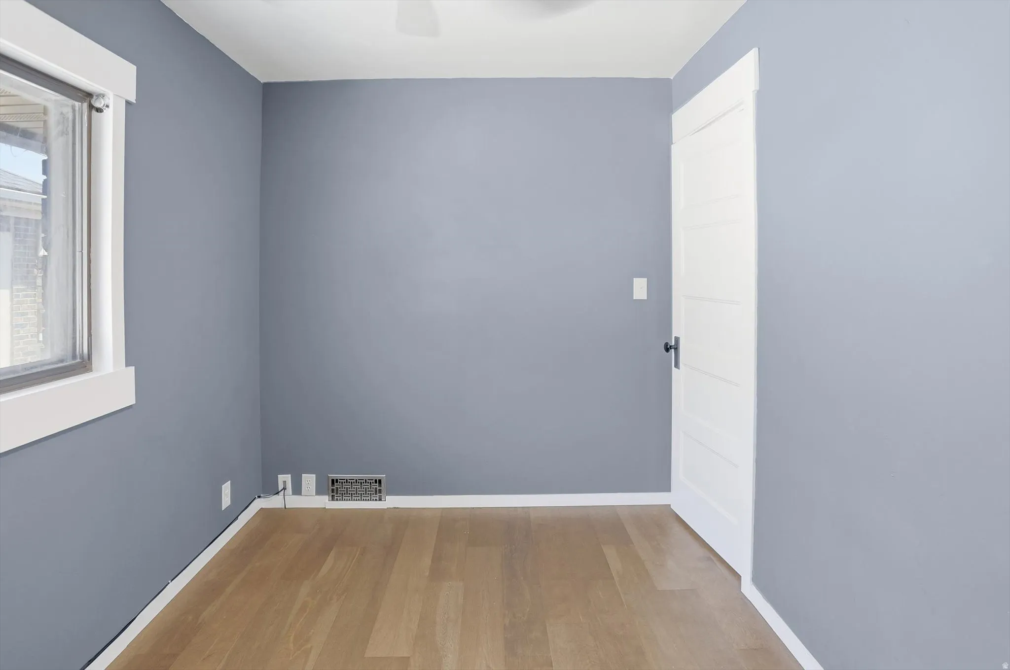 Empty room featuring light wood-style floors and a ceiling fan