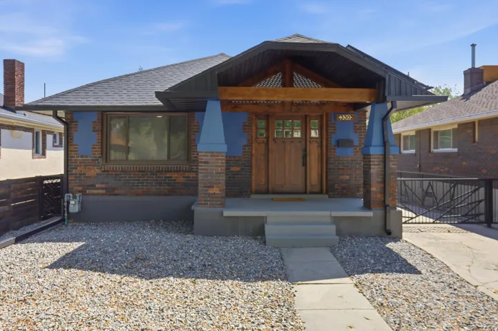 View of front of house featuring brick siding and a shingled roof