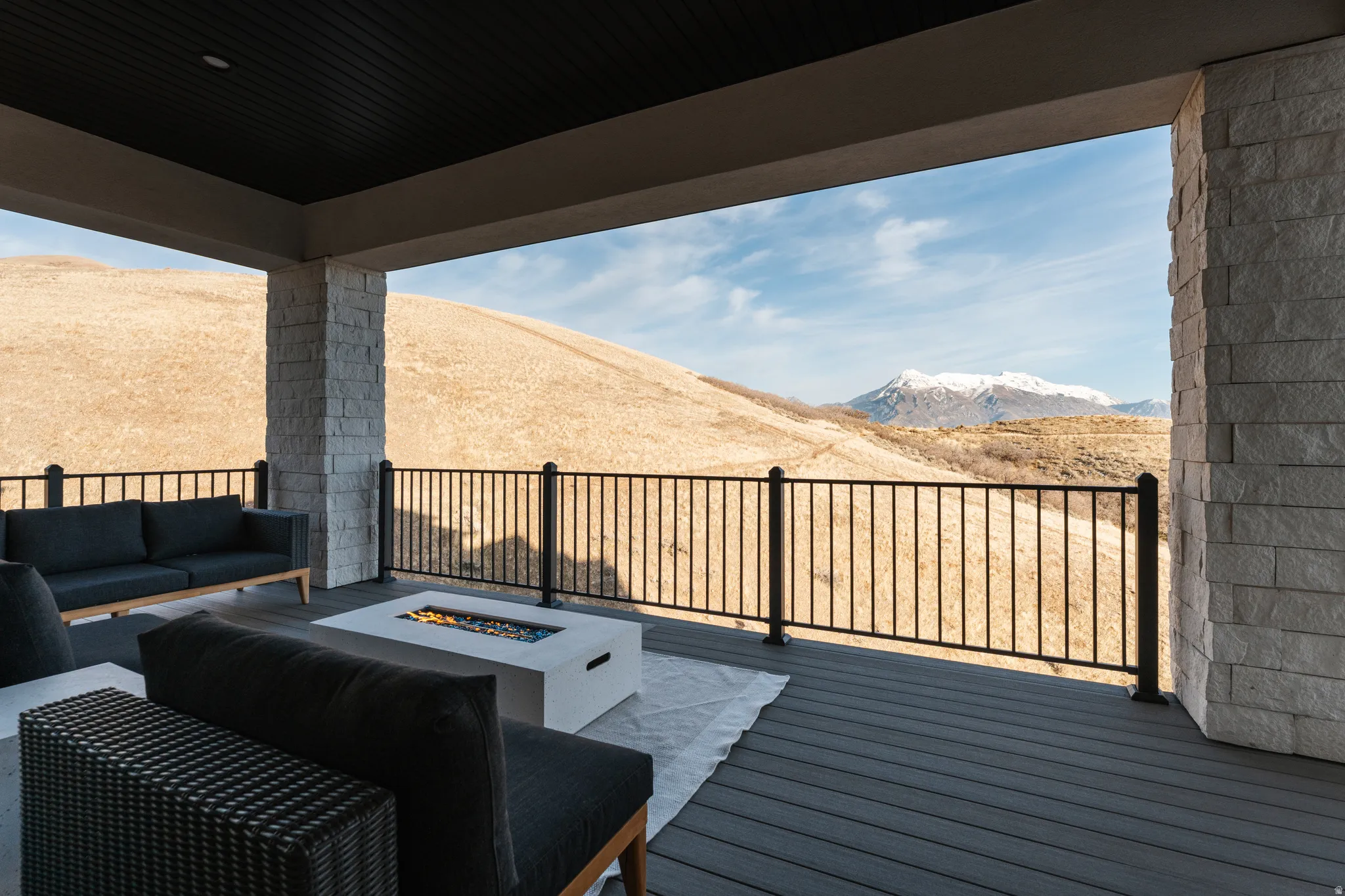 Wooden terrace featuring an outdoor living space with a fire pit and a mountain view