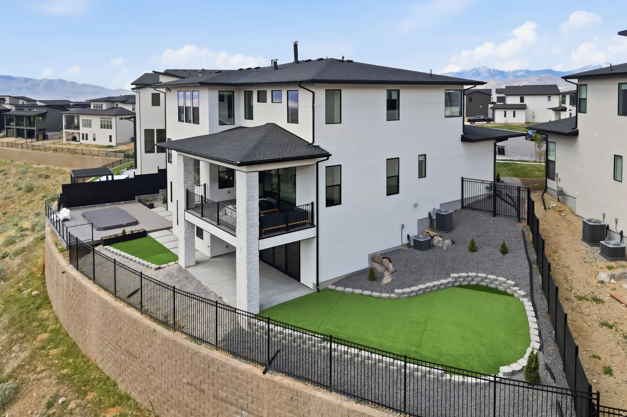 Lot goes down past retaining wall to fully capture 1/2 acre potential. Rear view of house featuring a mountain view, a residential view, and a fenced backyard