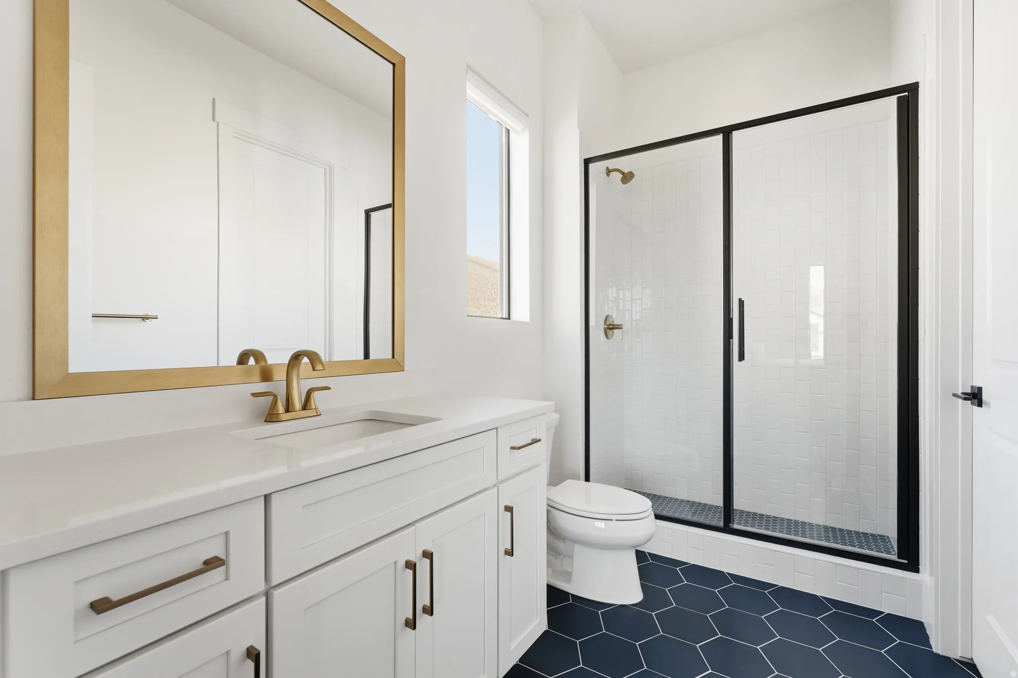 Full bathroom with vanity, a stall shower, and dark tile patterned flooring