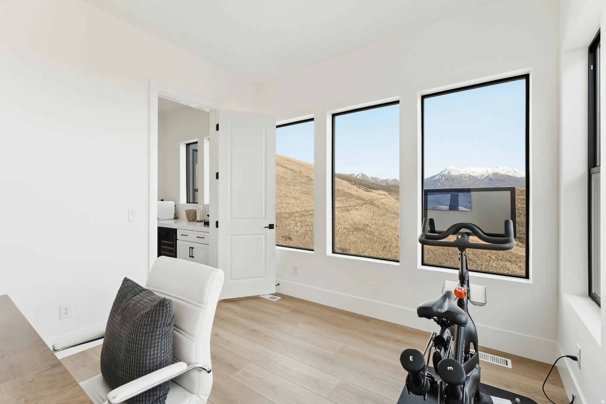 Exercise area featuring baseboards and light wood-style floors