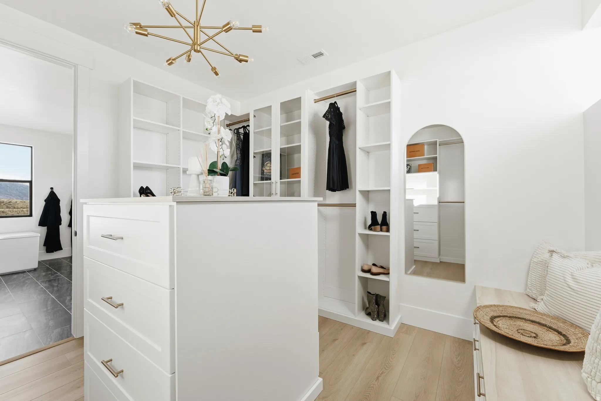 Walk in closet featuring light wood finished floors and suspended lighting