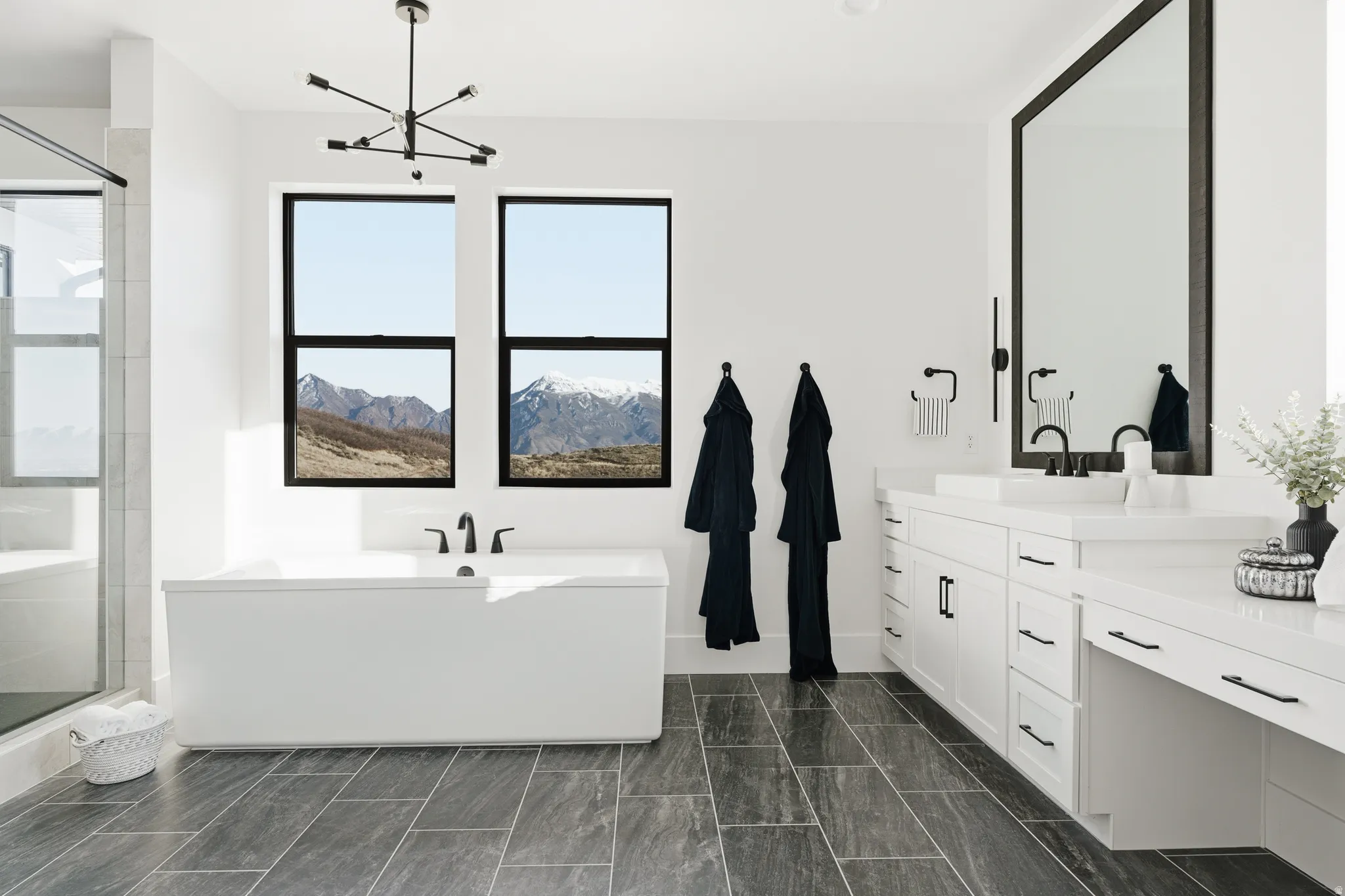 Bathroom with vanity, a bath, a stall shower, and hanging lights