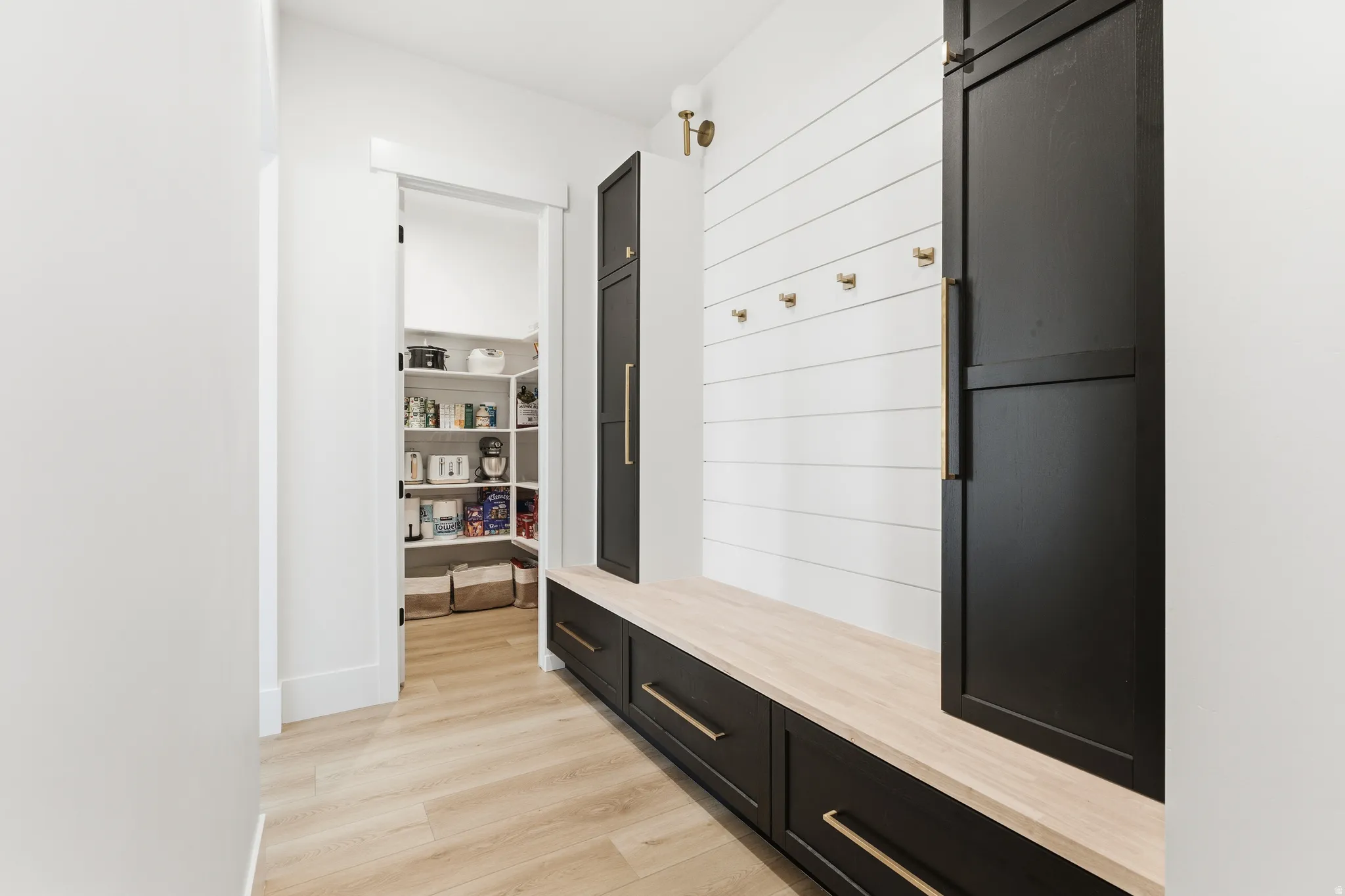 Mudroom with light wood-style floors and baseboards