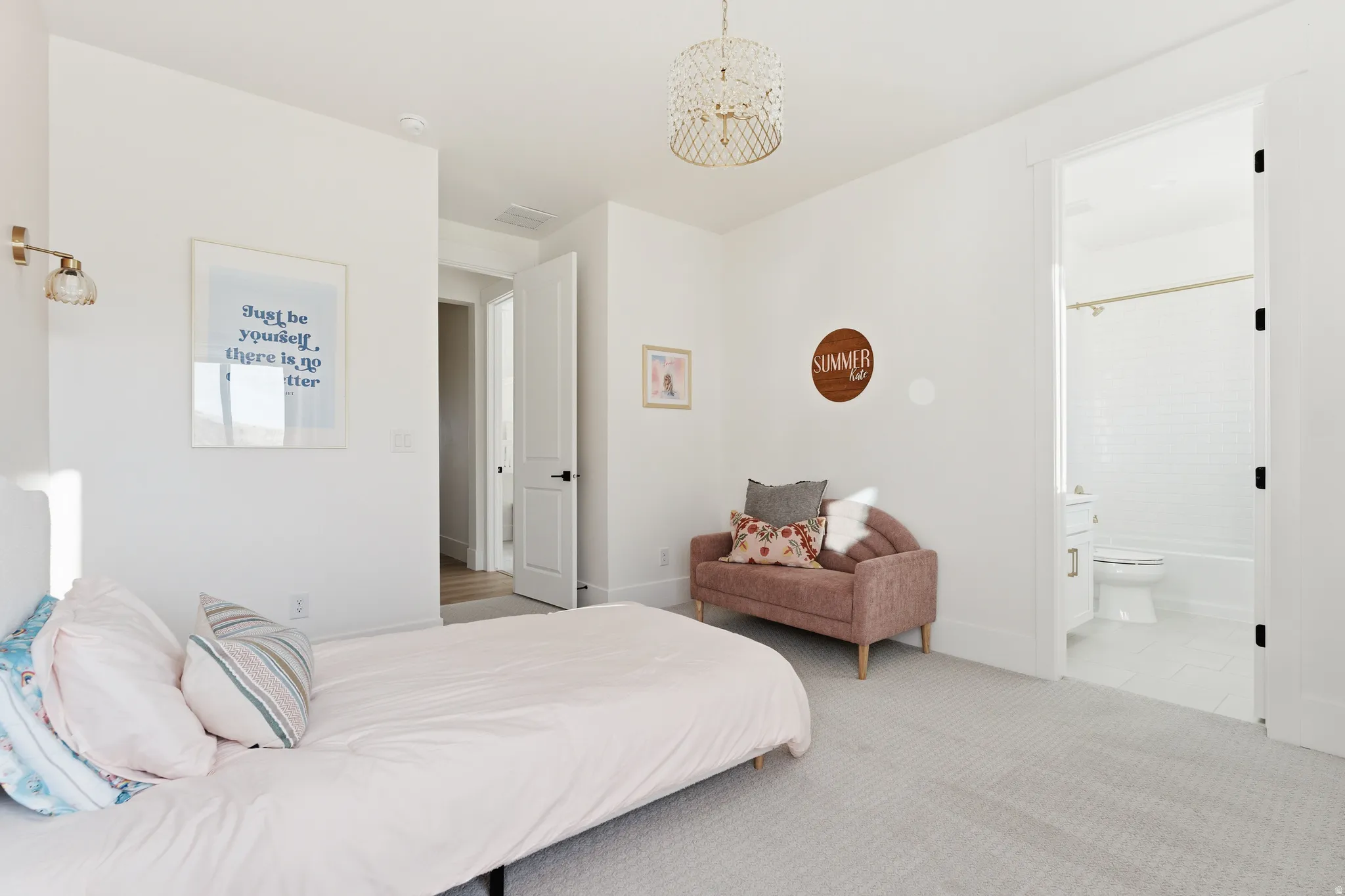 Bedroom with carpet floors, suspended lighting, and ensuite bathroom