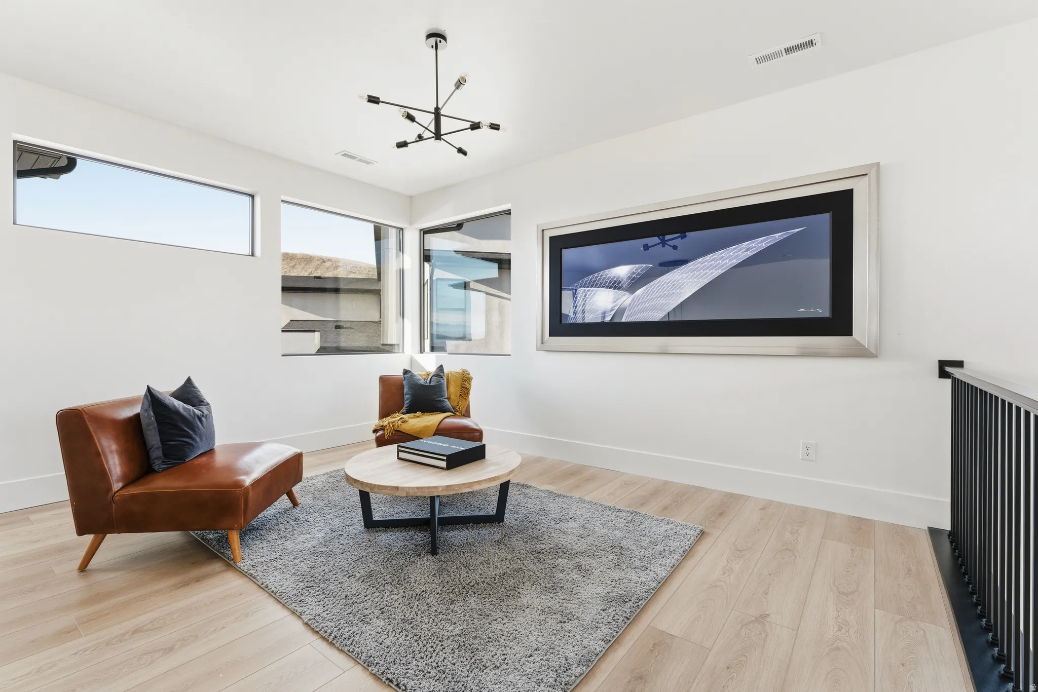 Sitting room with light wood-type flooring and hanging lights