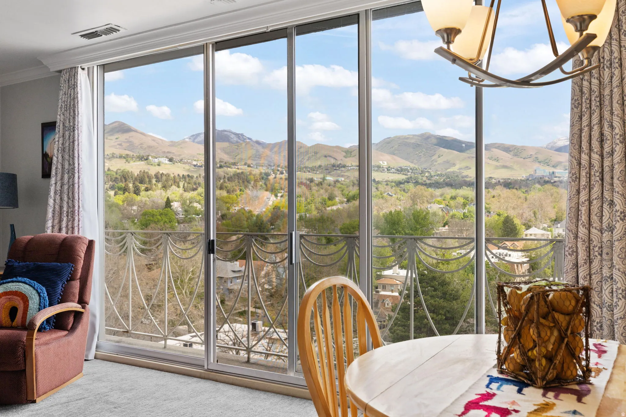 Sunroom with a mountain view, hanging lights, and view of wooded area