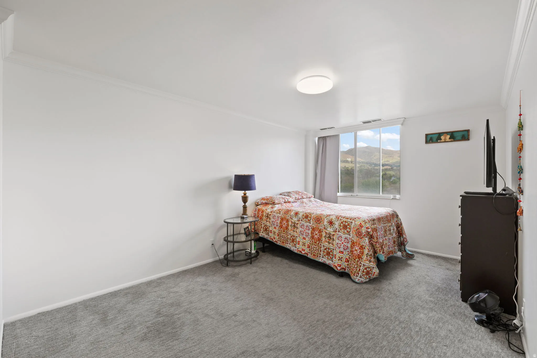 Carpeted bedroom featuring crown molding and baseboards