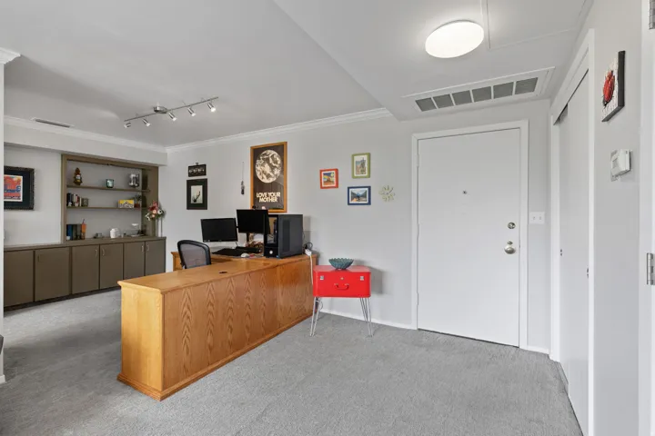 Office area featuring ornamental molding, light carpet, and rail lighting
