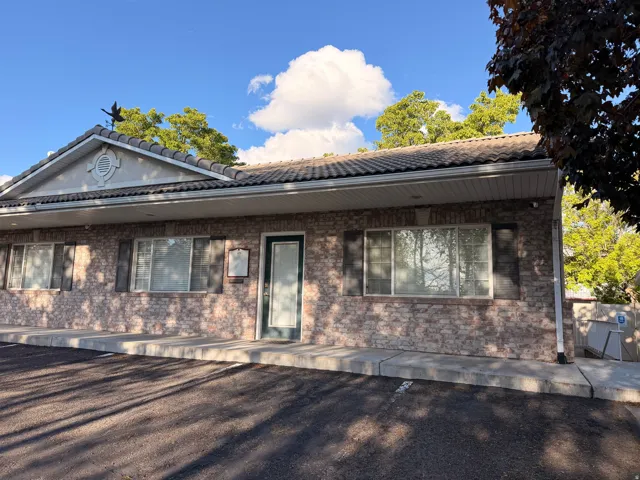 View of front facade featuring a tiled roof and brick siding