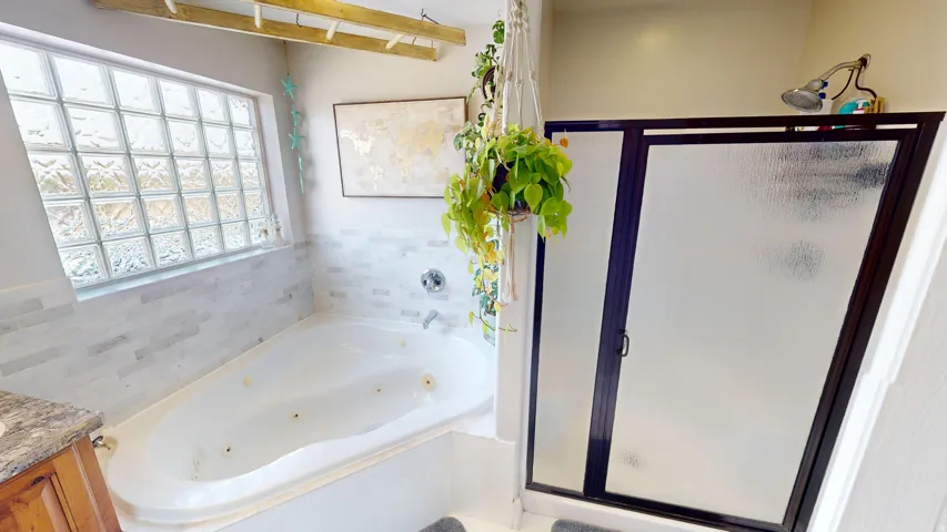 Primary Full bathroom featuring a shower stall, vanity, and a jetted tub