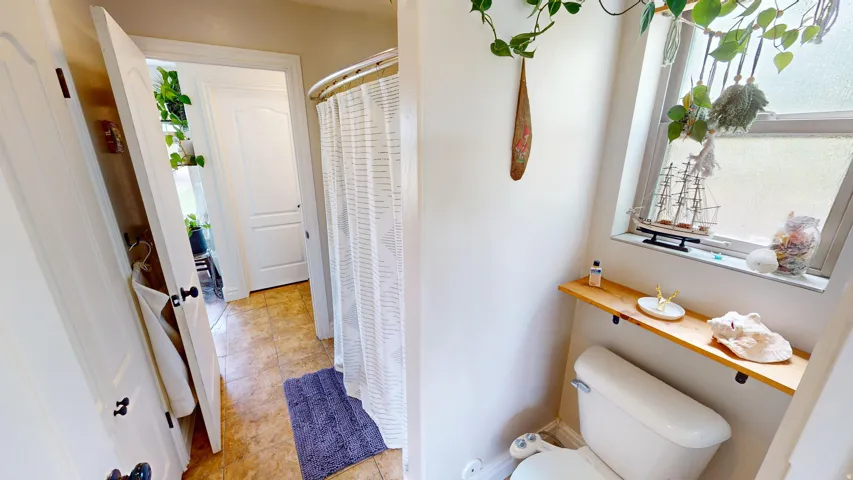 Full Jack and Jill bath featuring a shower with curtain and light tile patterned flooring