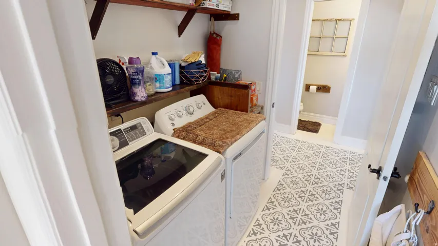 Laundry room featuring washer and dryer and light tile patterned flooring