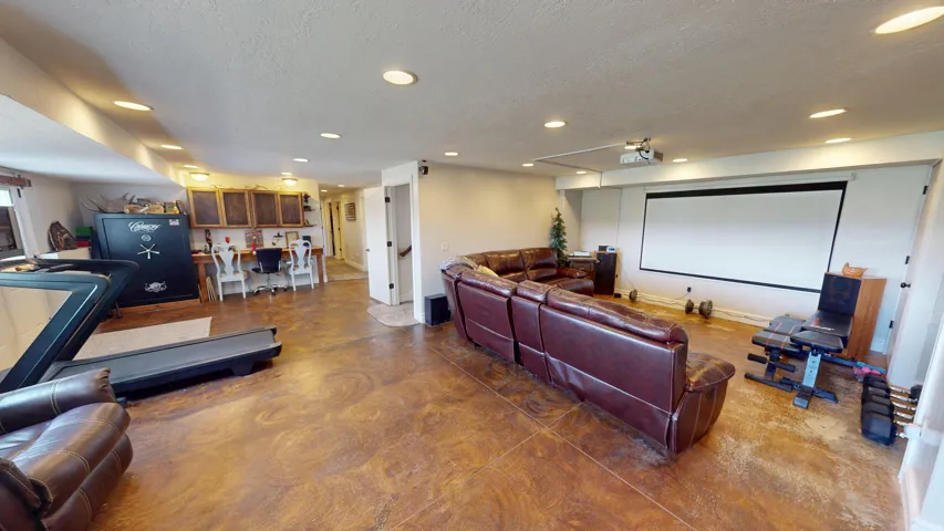 Cinema room with concrete floors, recessed lighting, and a textured ceiling