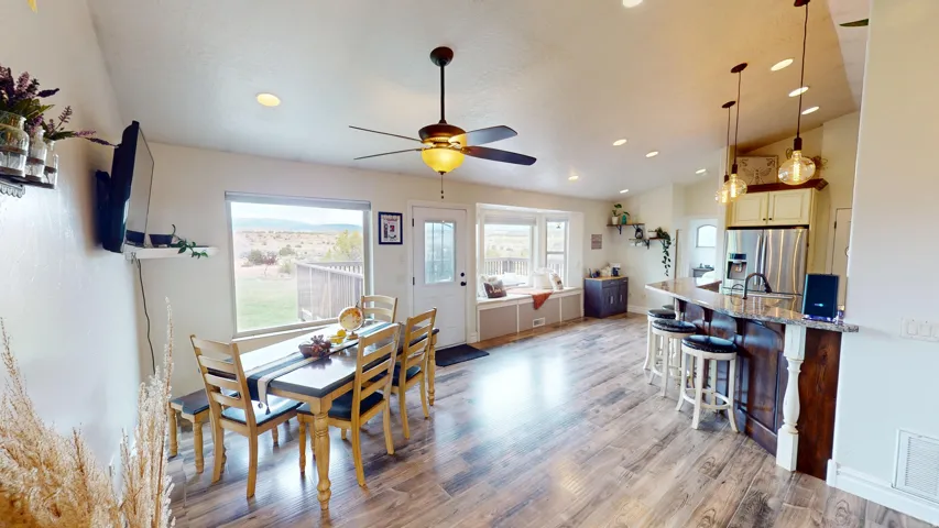 Dining space featuring light wood-style flooring, a ceiling fan, vaulted ceiling, and recessed lighting