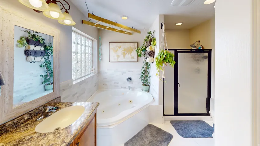 Primary Bathroom with a shower stall, vanity, a whirlpool tub, and light tile patterned flooring