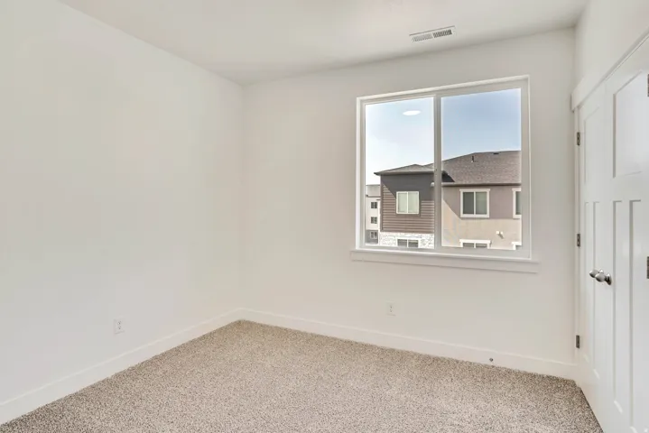 Carpeted spare room featuring baseboards