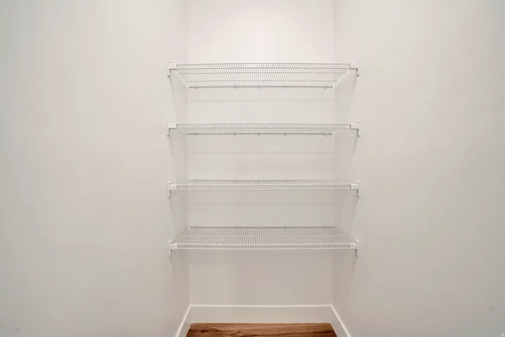Walk in closet with light wood-type flooring