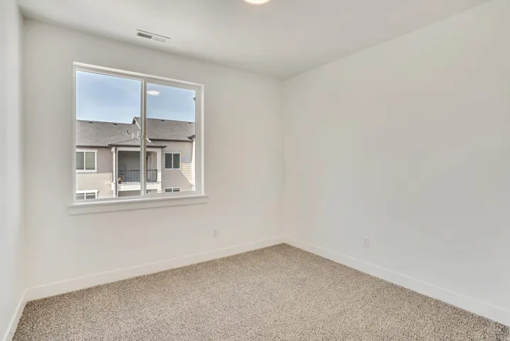 Empty room featuring baseboards and carpet flooring
