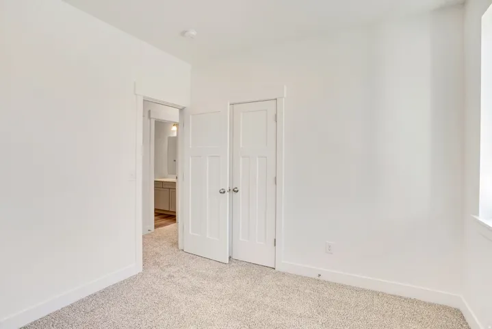 Unfurnished bedroom featuring light colored carpet and a closet