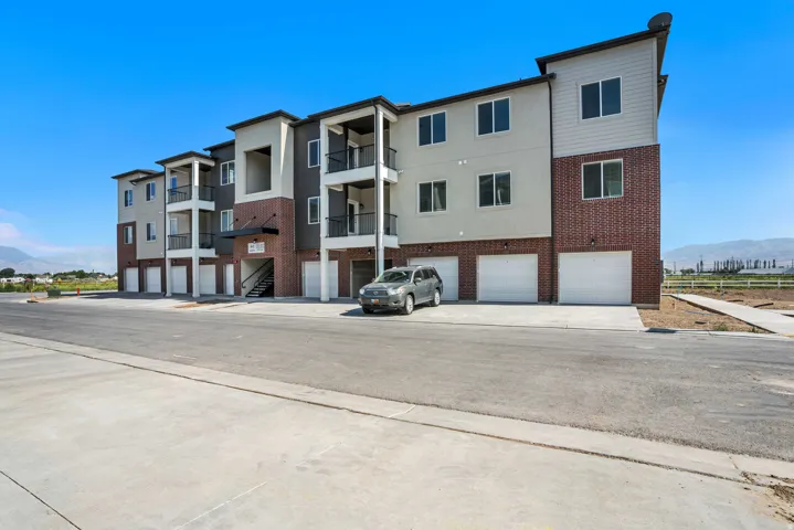 View of property with a garage, a mountain view, and driveway