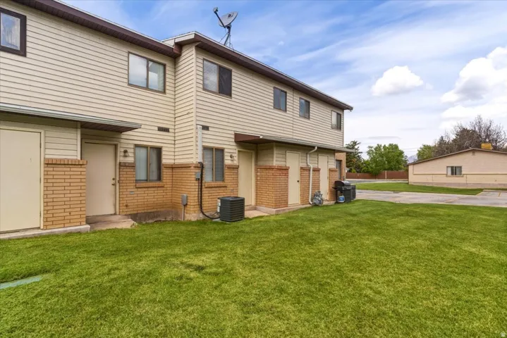 Rear view of property featuring brick siding and a yard