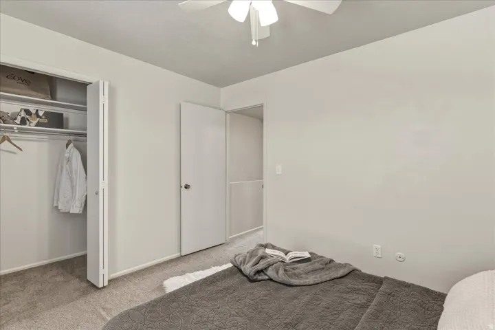 Unfurnished bedroom with carpet floors, ceiling fan, and a closet