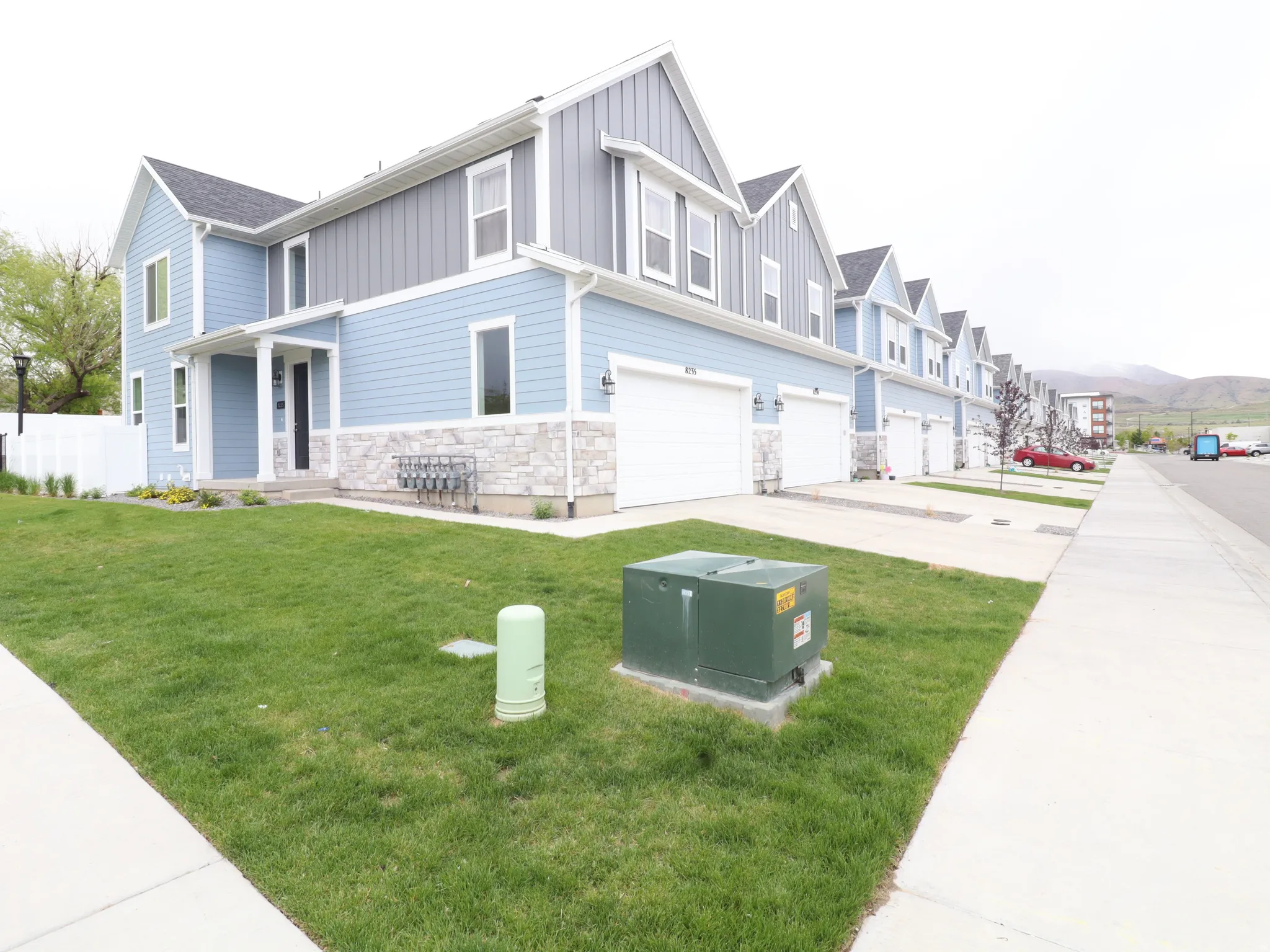 View of front facade with a garage, board and batten siding, stone siding, a residential view, and concrete driveway