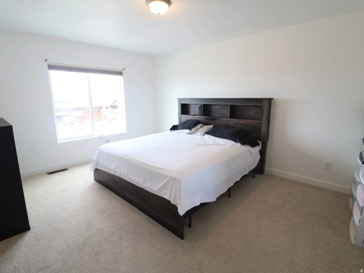 Bedroom with light colored carpet and baseboards