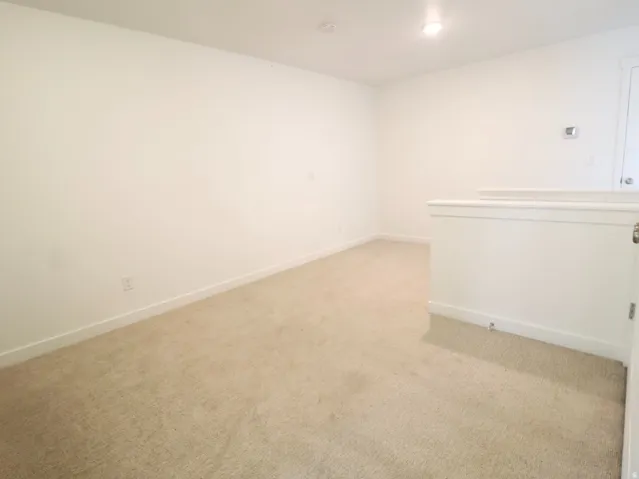 Unfurnished room with light colored carpet and baseboards
