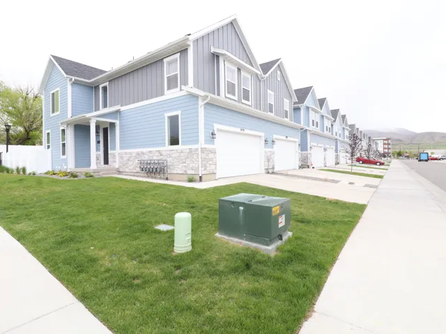View of front facade with a garage, board and batten siding, stone siding, a residential view, and concrete driveway