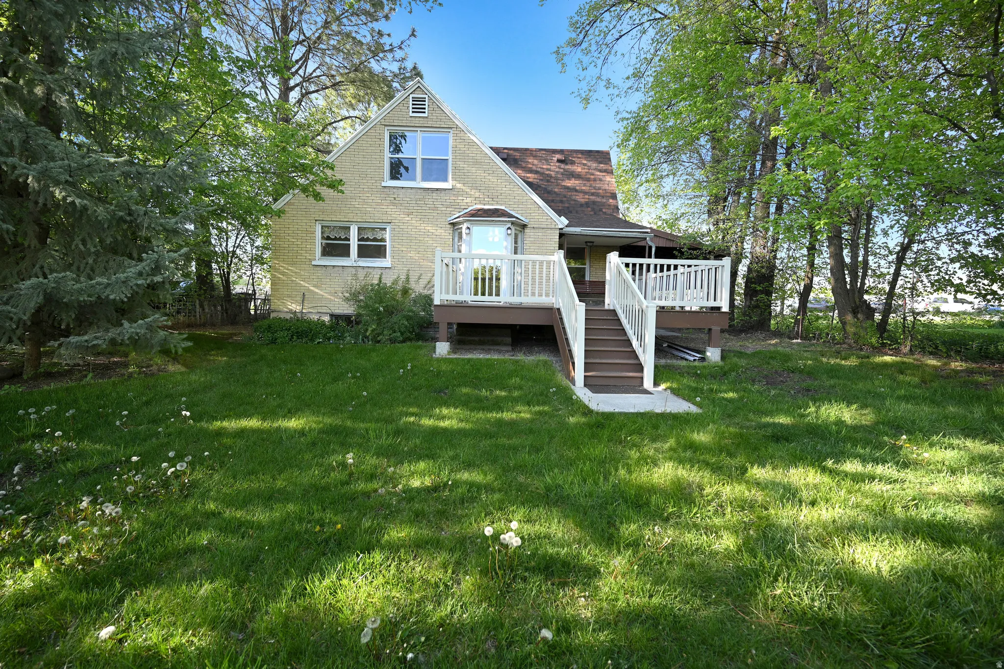 Back of property with a yard and deck